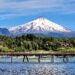 A view of a long pier on Villarrica Lake with the Villarrica volcano in the background; Pucon, Chile