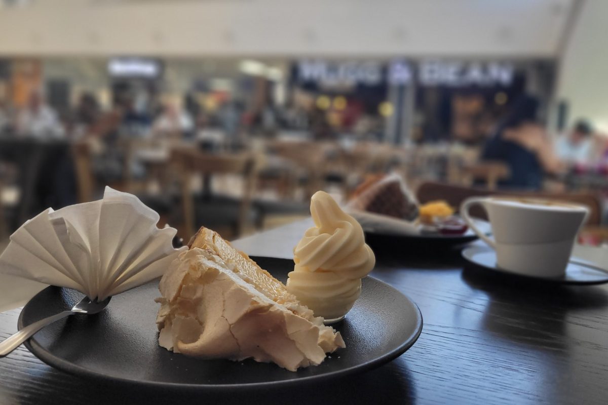 A generous serving of lemon merengue pie, a side of ice cream and a cappuccino at Mugg & Bean coffee shop inside Blue Route Mall; Cape Town, South Africa